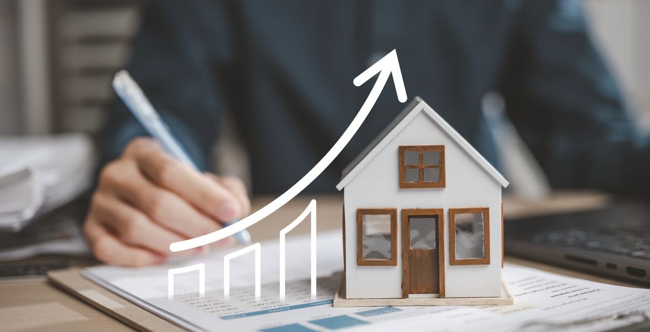 Modellhaus auf Unterlagen mit steigender Preisgrafik – Marktanalyse vom Immobilienmakler Traunstein
