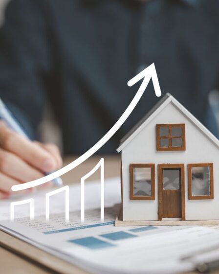 Modellhaus auf Unterlagen mit steigender Preisgrafik – Marktanalyse vom Immobilienmakler Traunstein