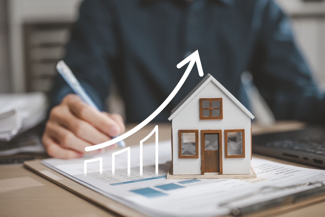 Modellhaus auf Unterlagen mit steigender Preisgrafik – Marktanalyse vom Immobilienmakler Traunstein