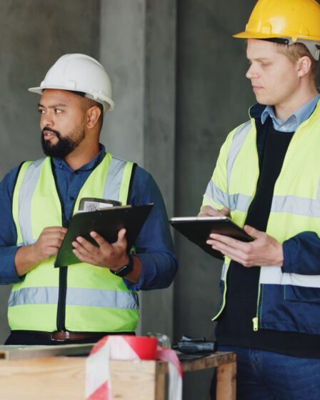 Baubesprechung mit Sicherheitshelmen und Westen | Absperrung Baustelle