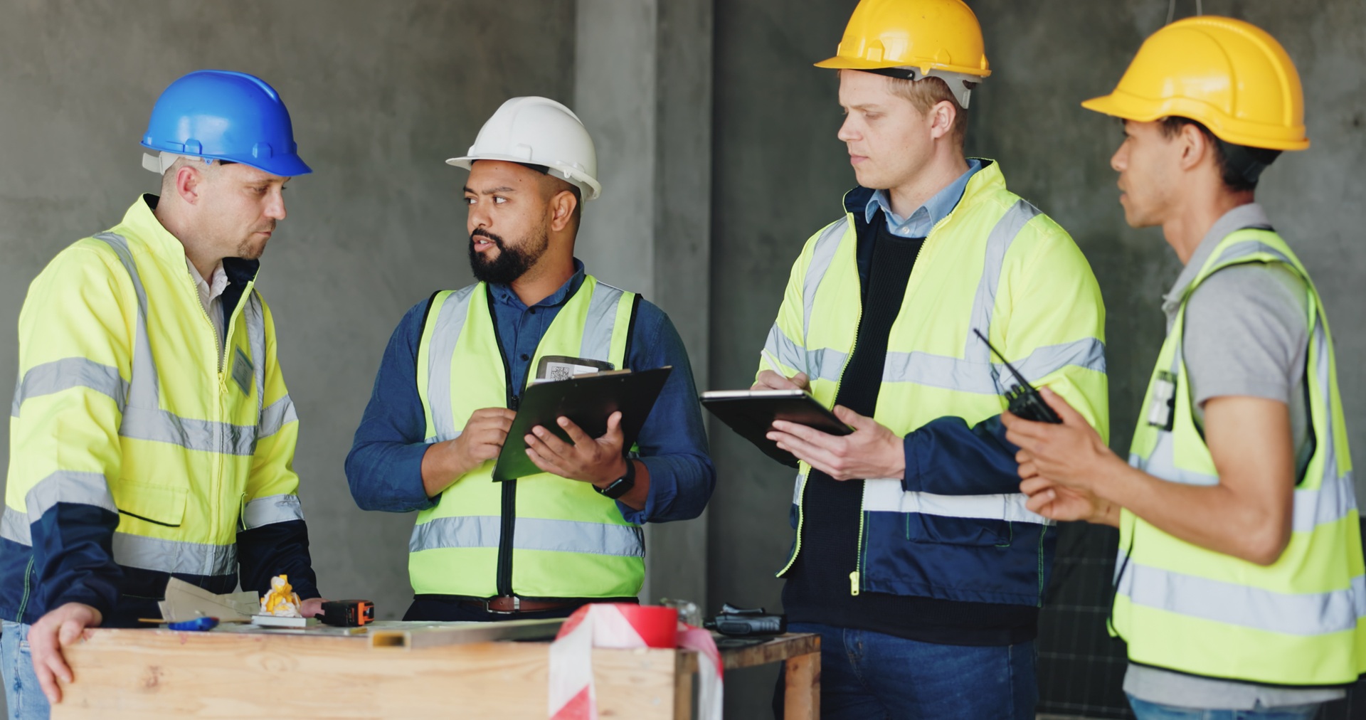 Baubesprechung mit Sicherheitshelmen und Westen | Absperrung Baustelle